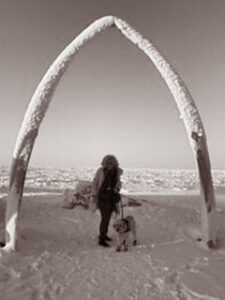 Crisis response canine team poses under whale bone arch in Utqiagvik (Barrow), Alaska.